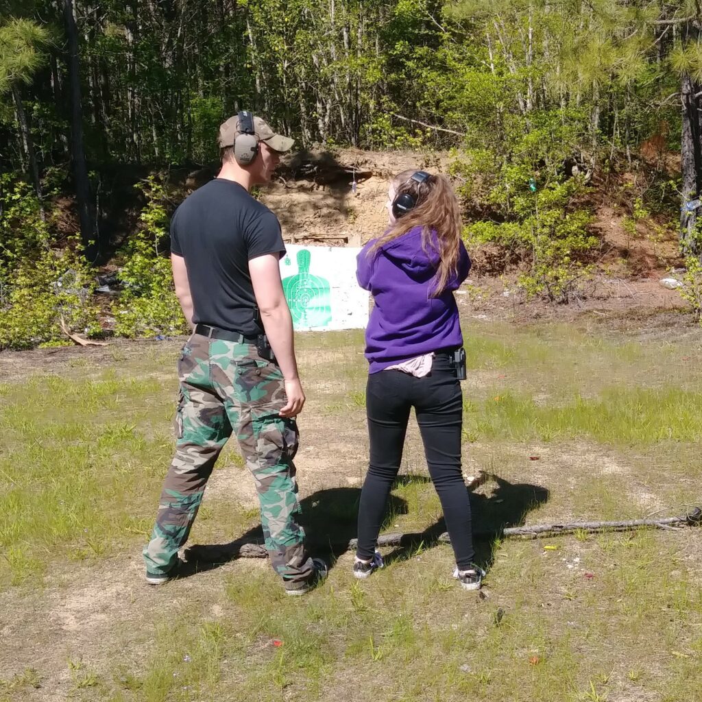 A young shooter trying out first guns with an instructor at the range