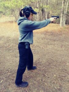 Demonstrating the modern isosceles stance with a pistol at a shooting range