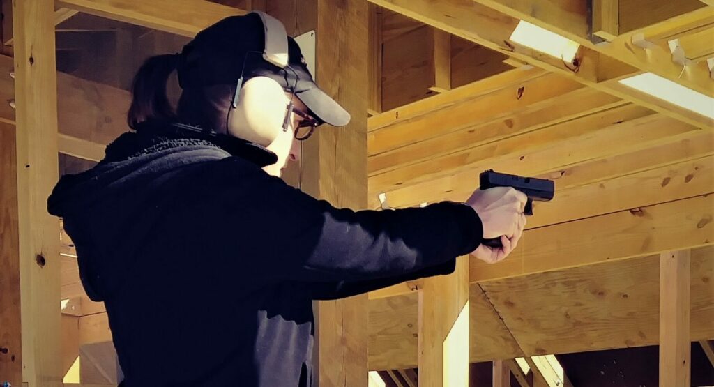 Alice shooting a pistol The author firing a pistol at the shooting range.