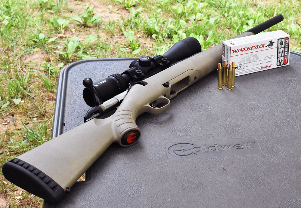 A 350 Legend rifle and ammo on a shooting bench at the range