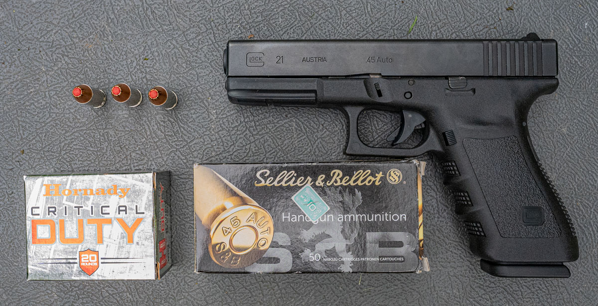 45 ACP ammo and a Glock pistol on a shooting bench