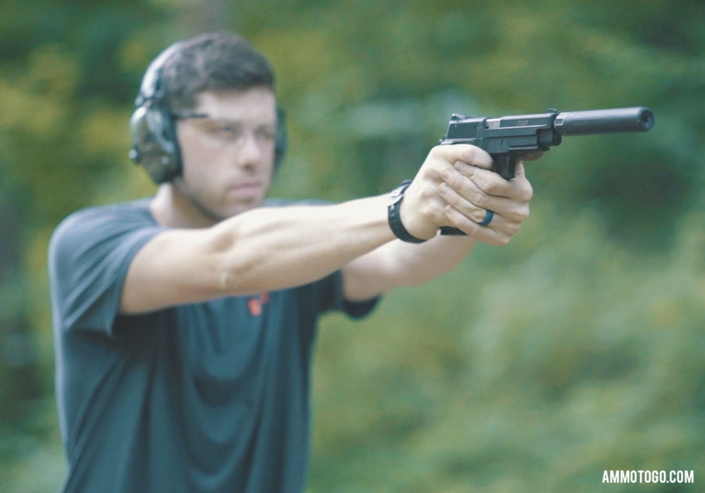 a man shooting a .22lr pistol with a silencer