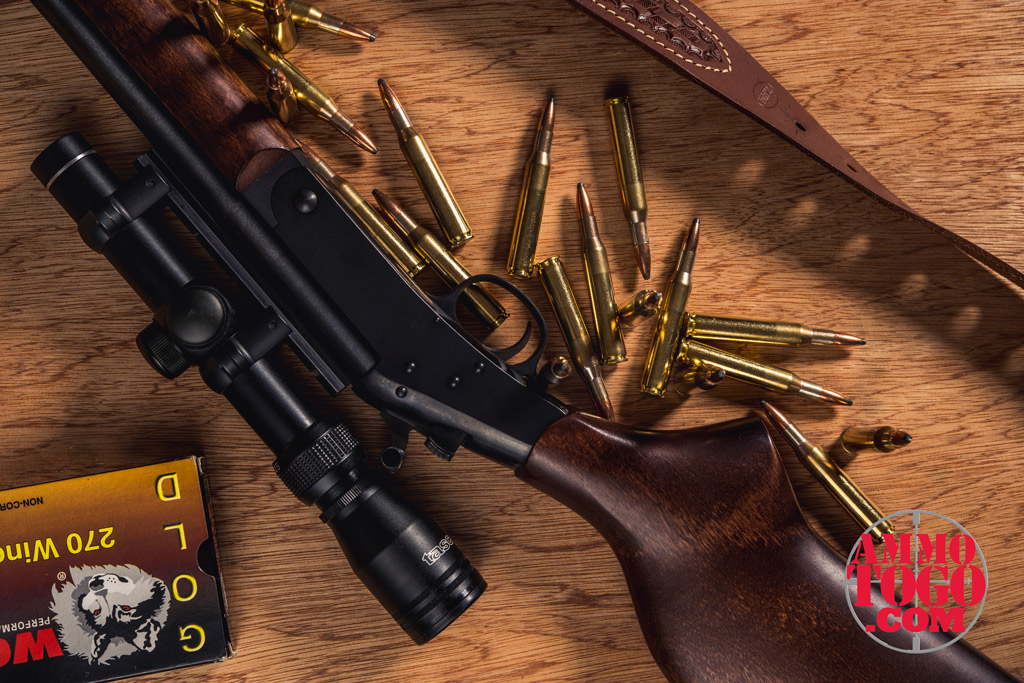 A .270 rifle with ammunition laying on a table Photo of New England Firearms rifle with Wolf .270 Winchester ammo