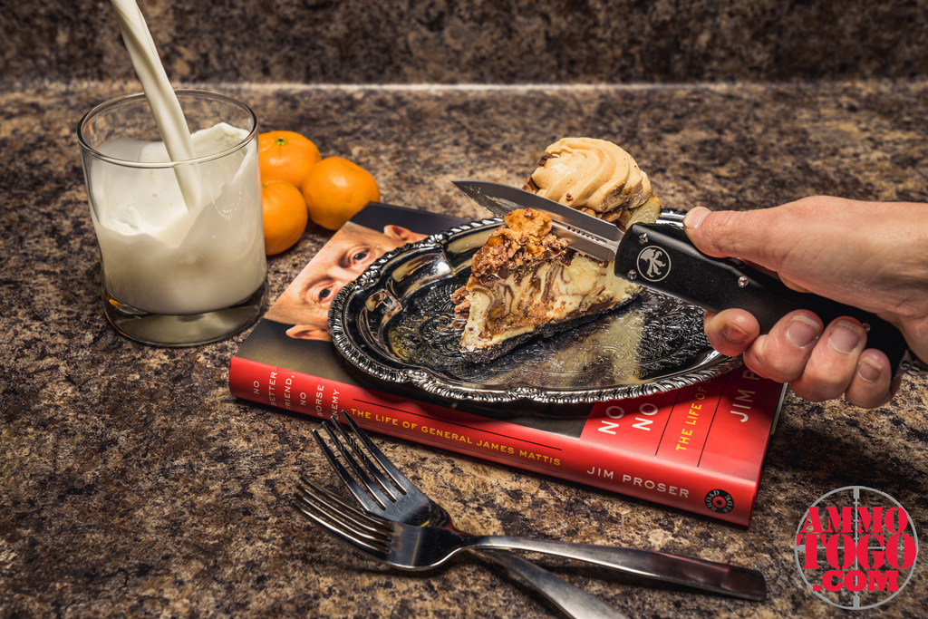 a photo of a woman cutting a cheesecake with a microtech switchblade knife