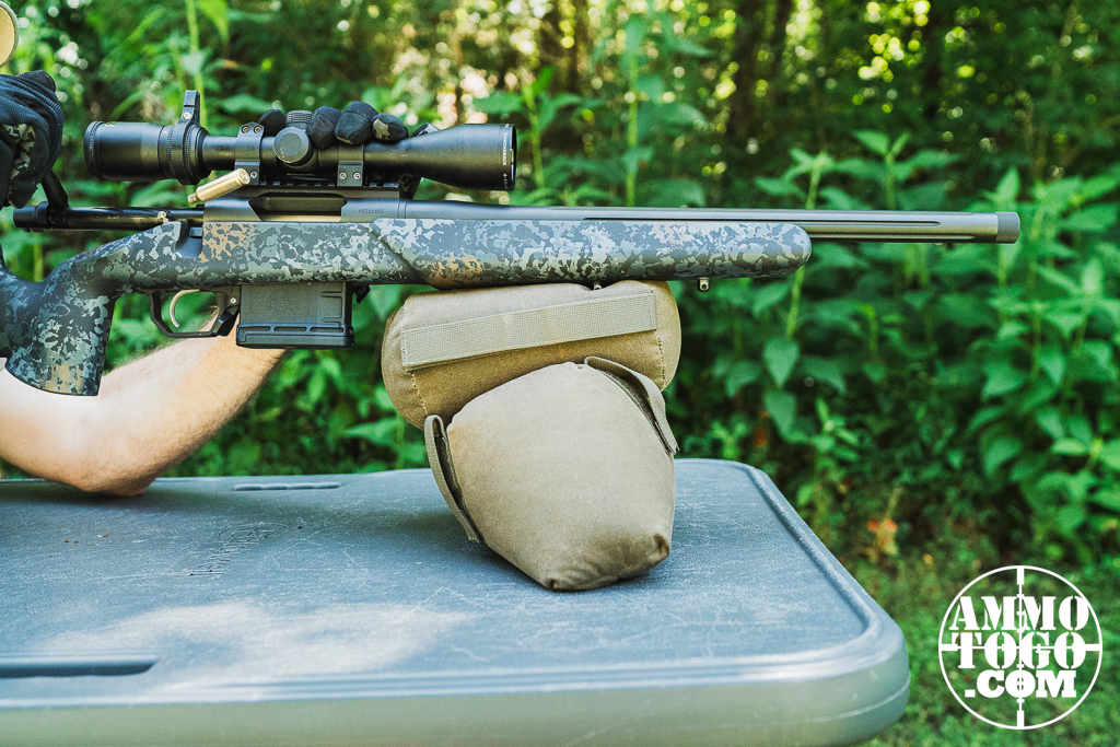 Firing a 22 Creedmoor rifle from a shooting bench at a range