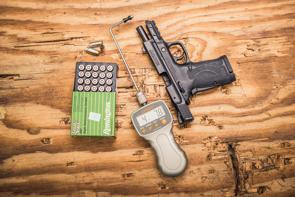 photo of a smith & wesson 9mm pistol with a trigger weight gauge