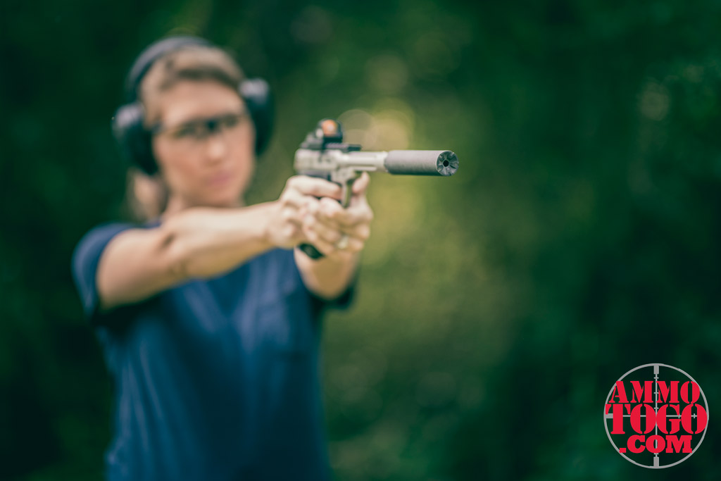 woman shooting while pregnant outdoors with a suppressed 22 pistol a photo of a woman shooting while pregnant outdoors with a suppressed 22 pistol