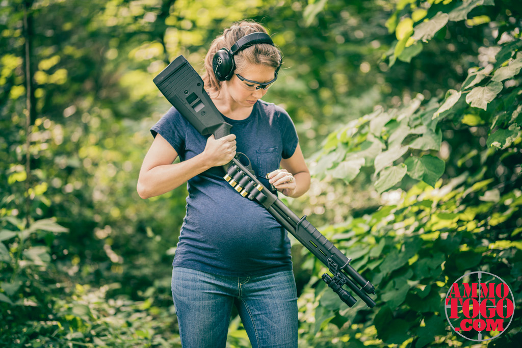 pregnant woman reloading a 12 gauge shotgun a pregnant woman reloading a 12 gauge shotgun outdoors
