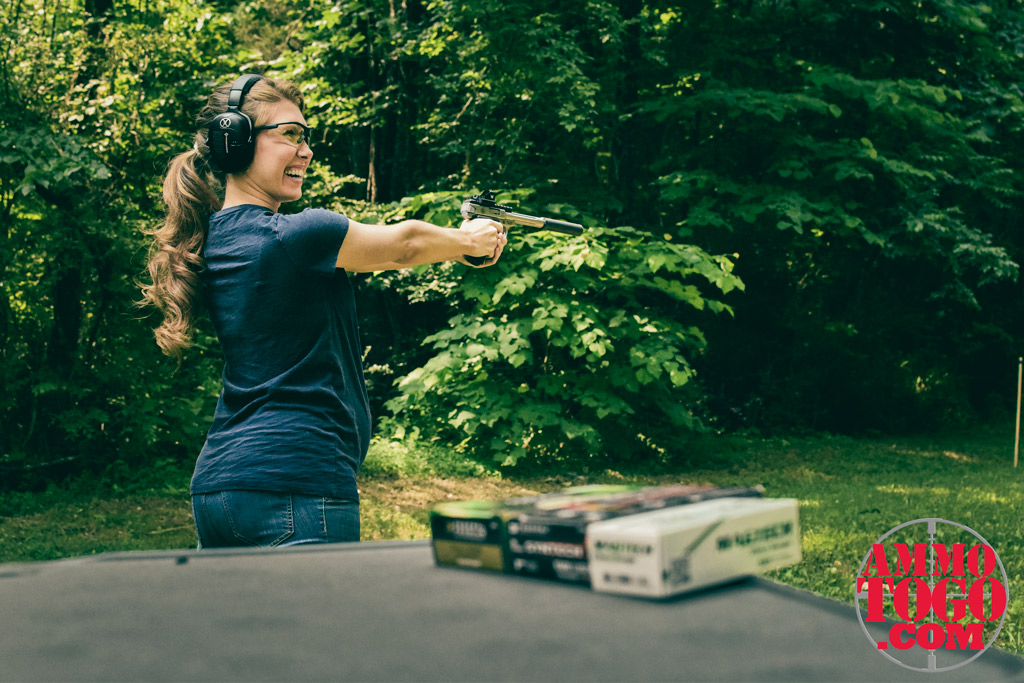A pregnant woman safely shooting a 22 long rifle handgun Pregnant woman shooting a pistol at an outdoor shooting range