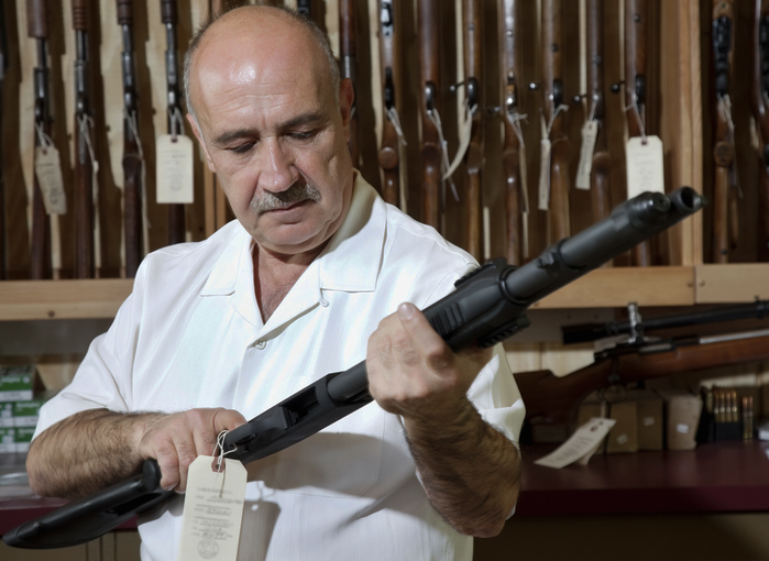 A Federal Firearms Licensee in his shop with a shotgun