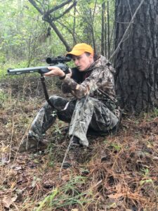 A hunter using a muzzleloader in the woods