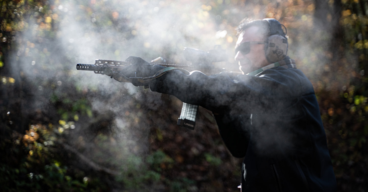 Firing a rifle at the range with muzzle blast all over