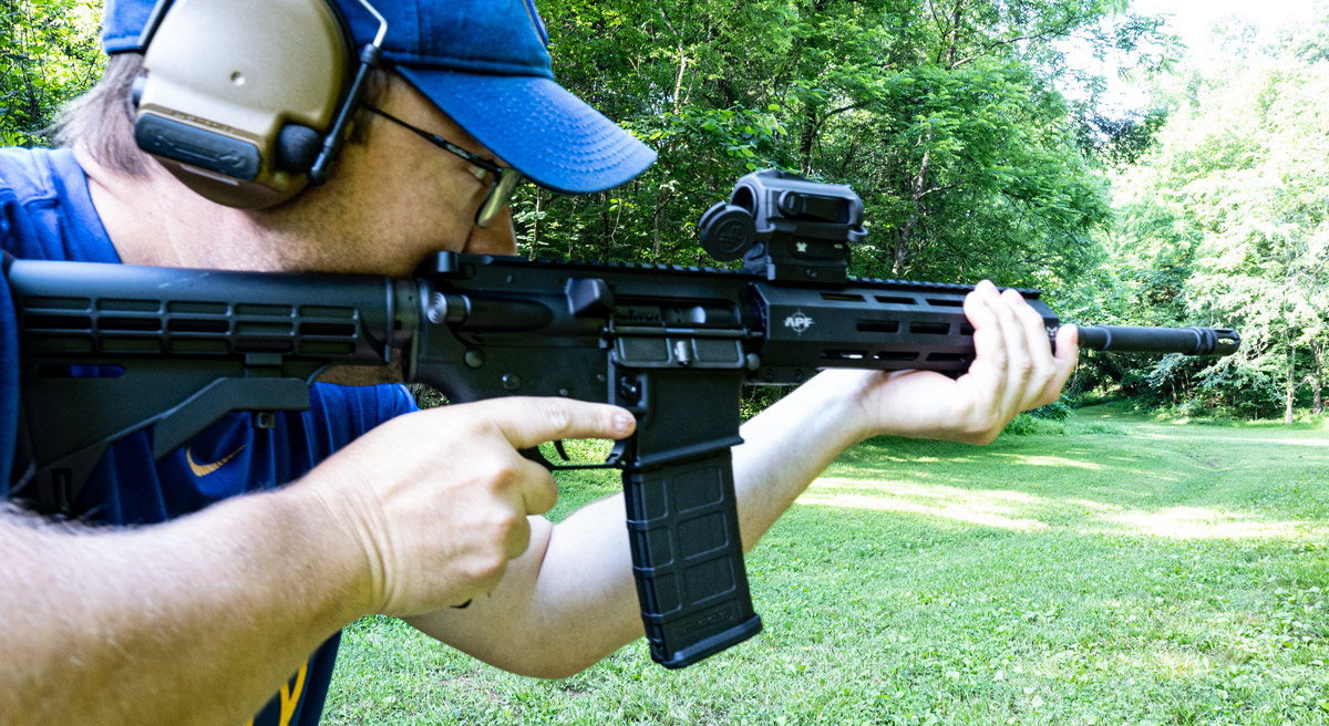 A shooter at the range with an AR15 firing rounds.