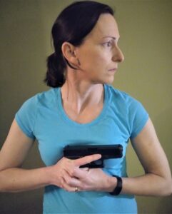 Author demonstrating holding the pistol close to the body