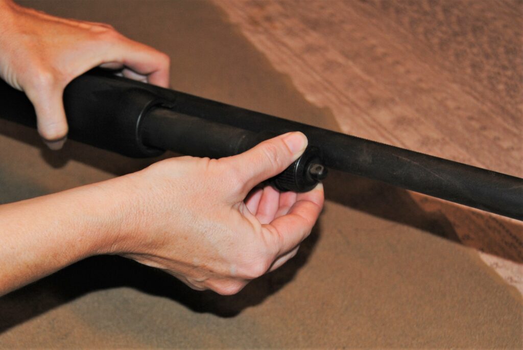 Removing the barrel of the shotgun to clean it
