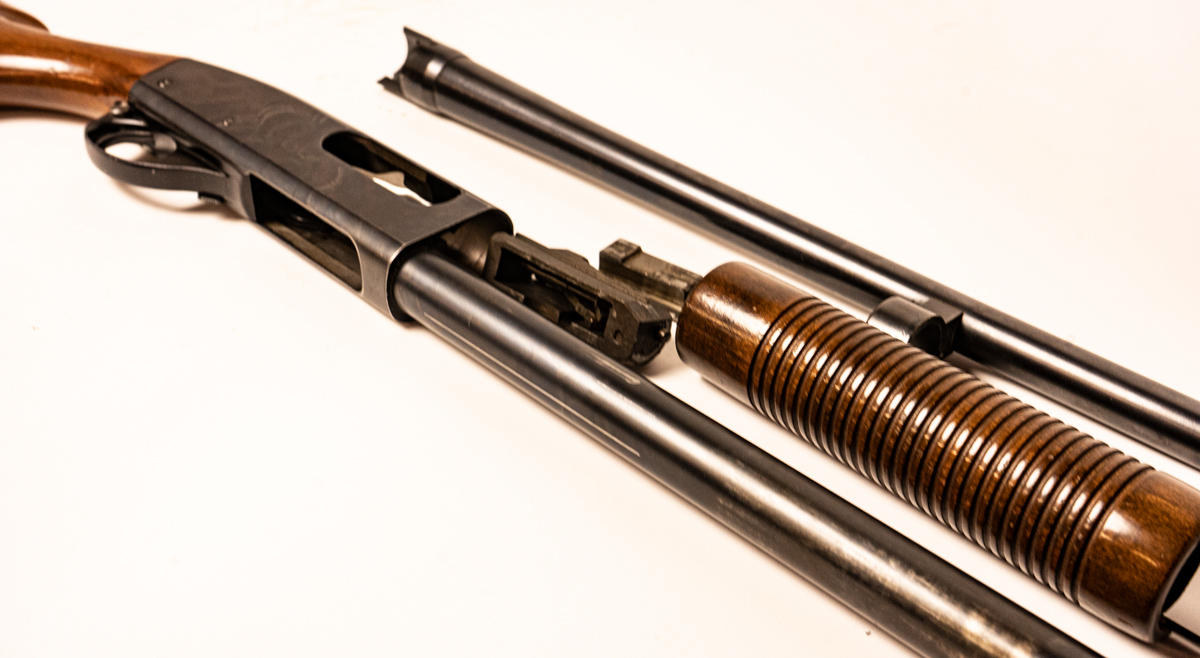 field stripped shotgun on a table