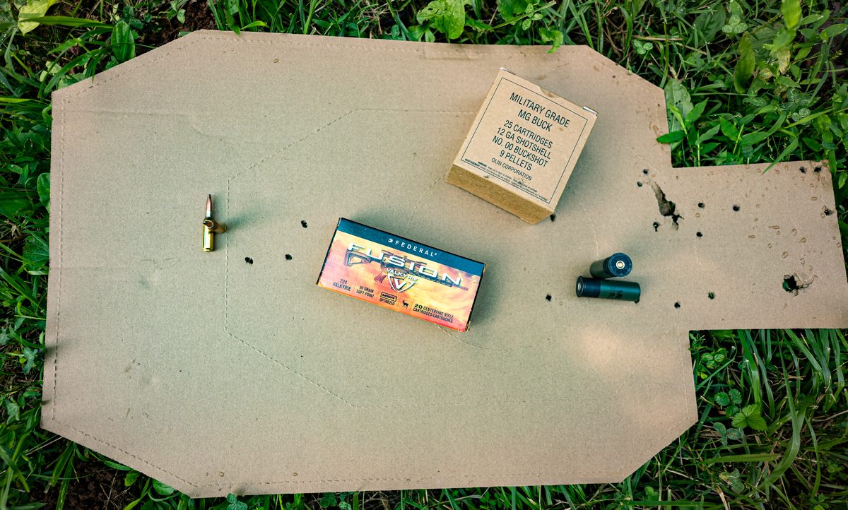 A cardboard target shot with both rifle and shotgun ammo
